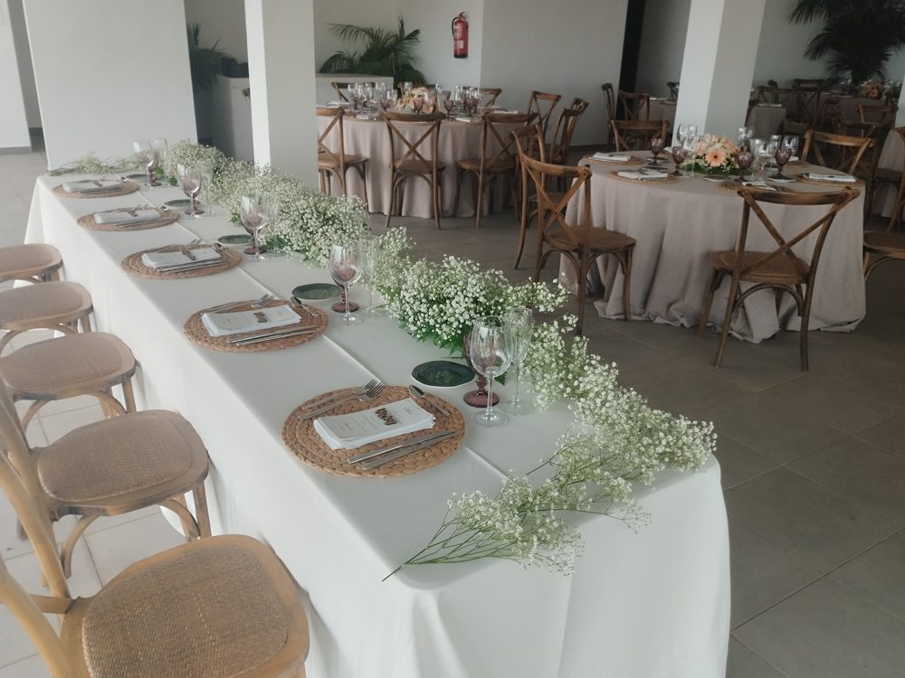 Mesa larga de banquete con flores blancas