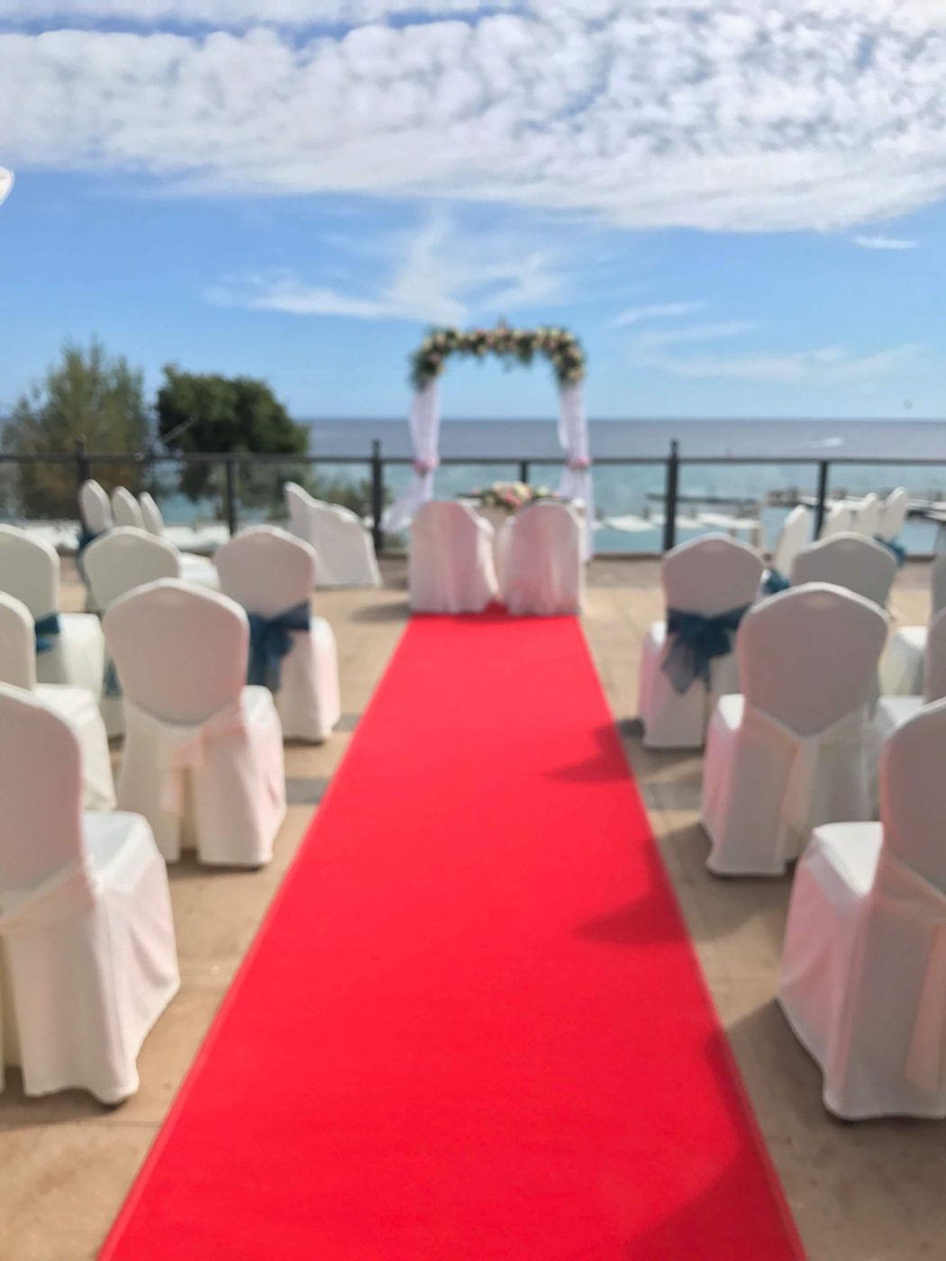 Alfombra roja y sillas blancas de ceremonia en jardín