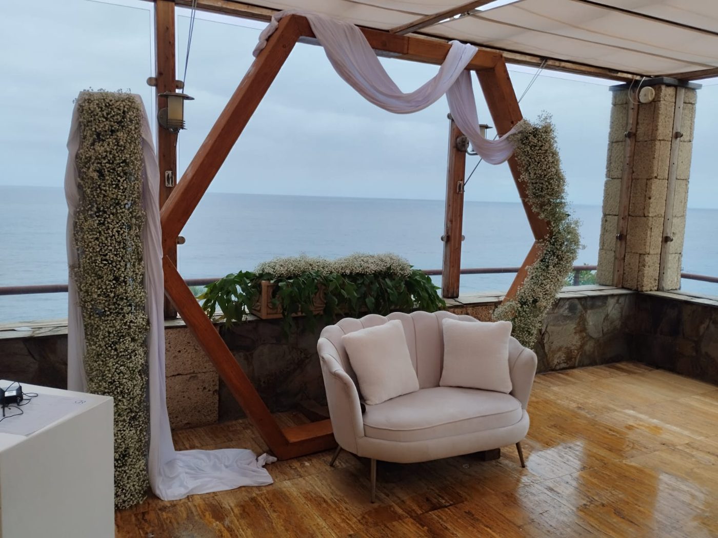 Arco hexagonal y sofá de ceremonia con vista completa al mar