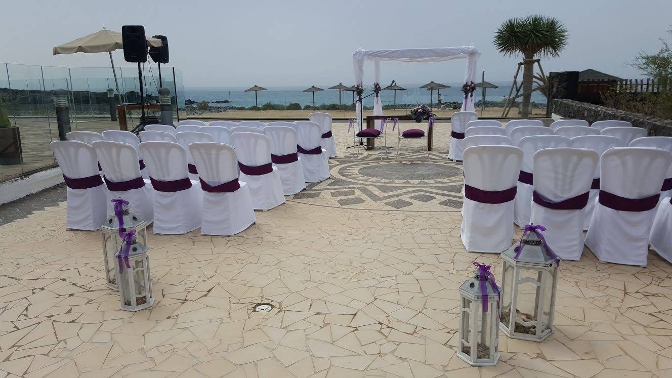 Arco de ceremonia en tonos morado y fucsia en la playa