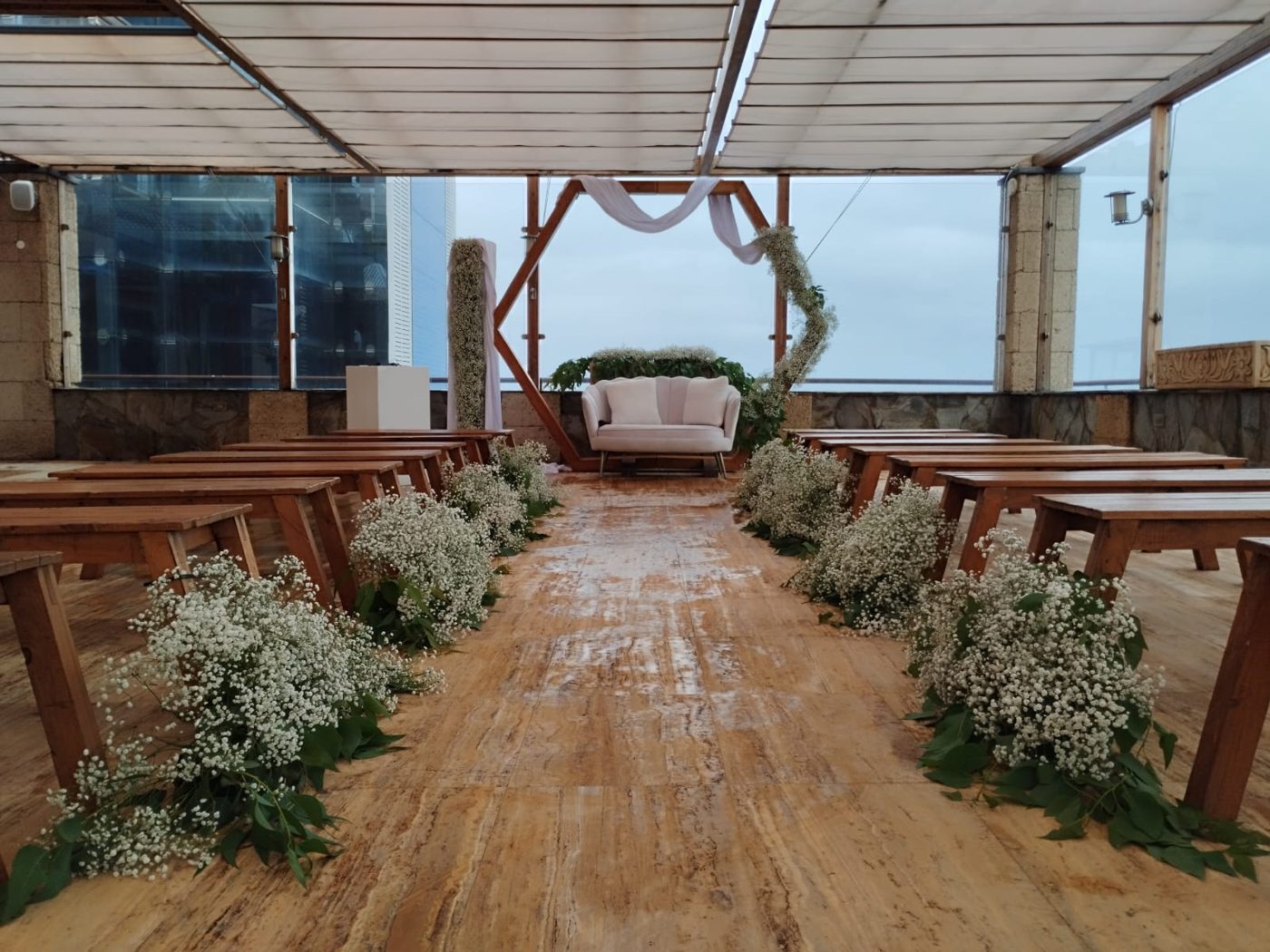 Columna floral y arco de ceremonia con sofá y vistas al mar