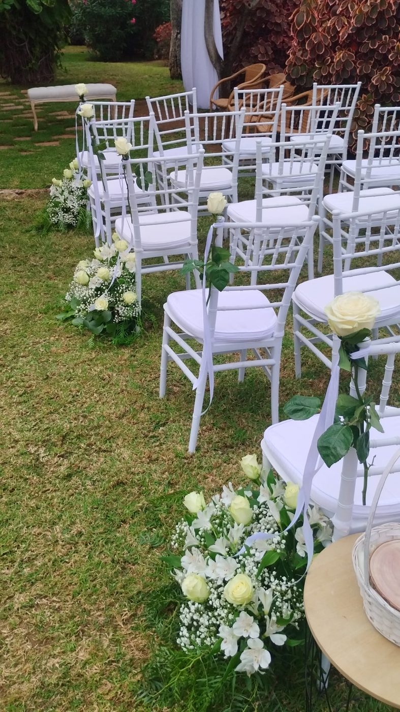 Detalle de sillas de pasillo con rosas y flor blanca