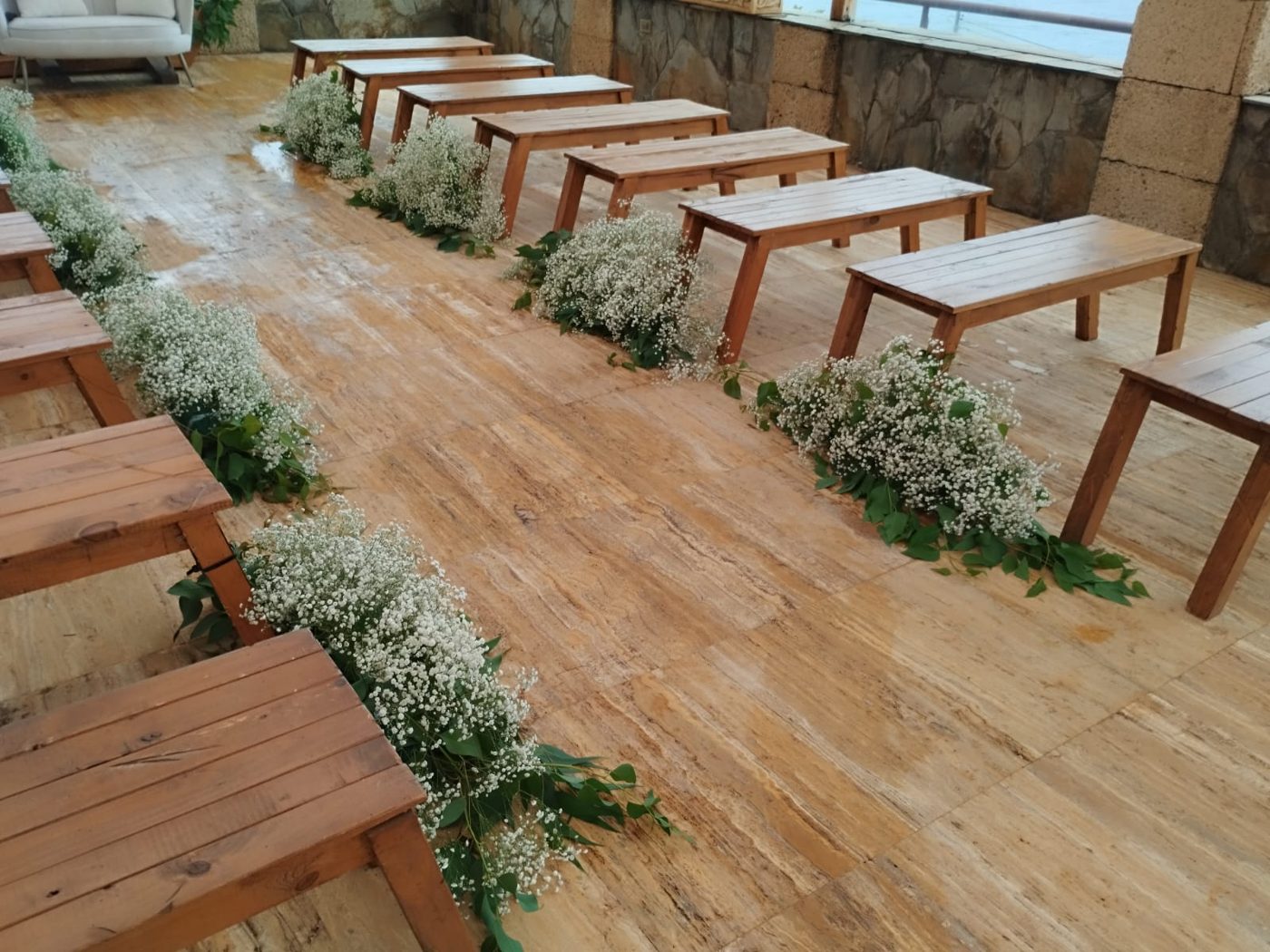 Pasillo de mesas de madera con flores, otra vista