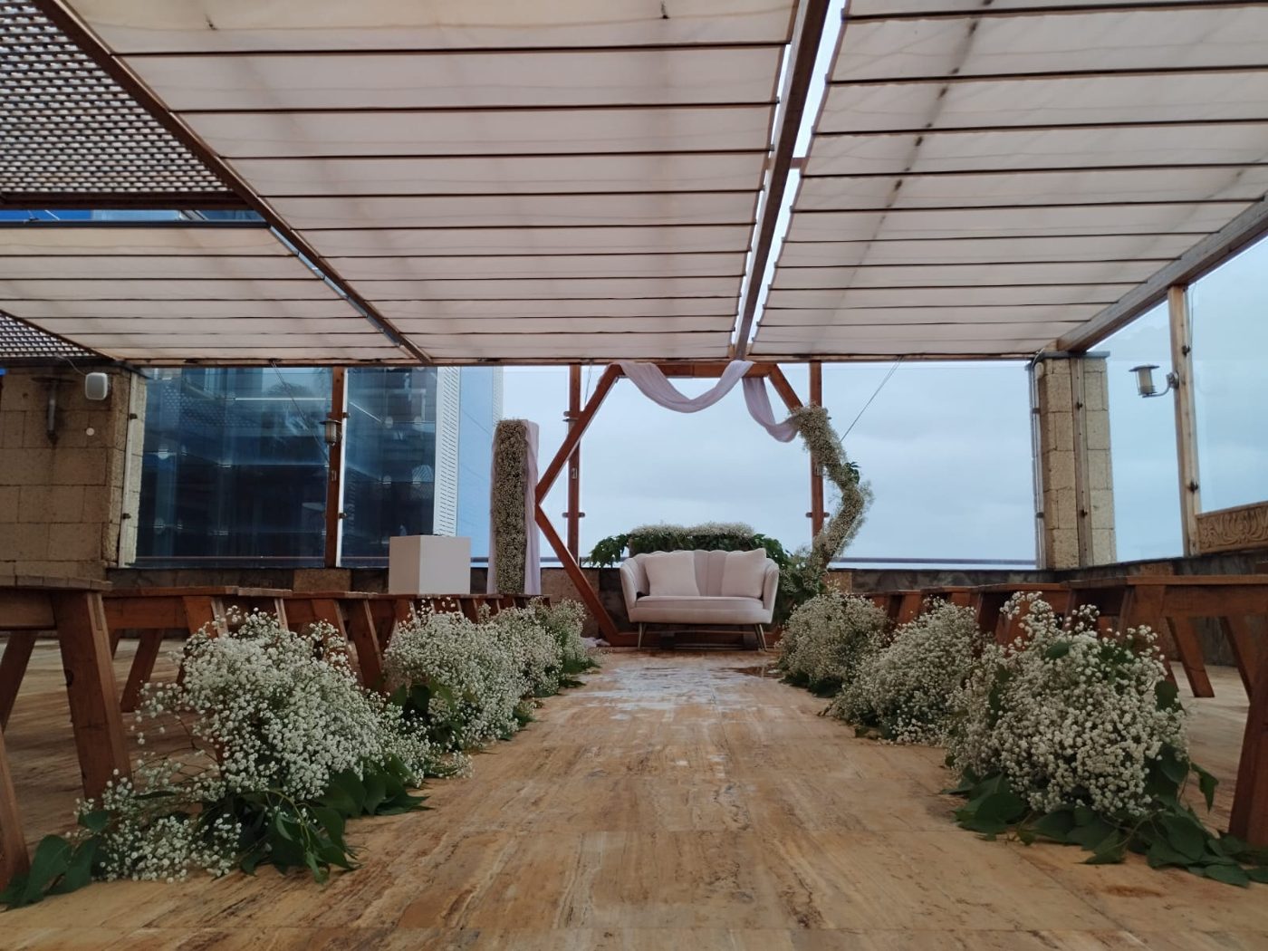 Terraza de ceremonia con sofá y arco hexagonal