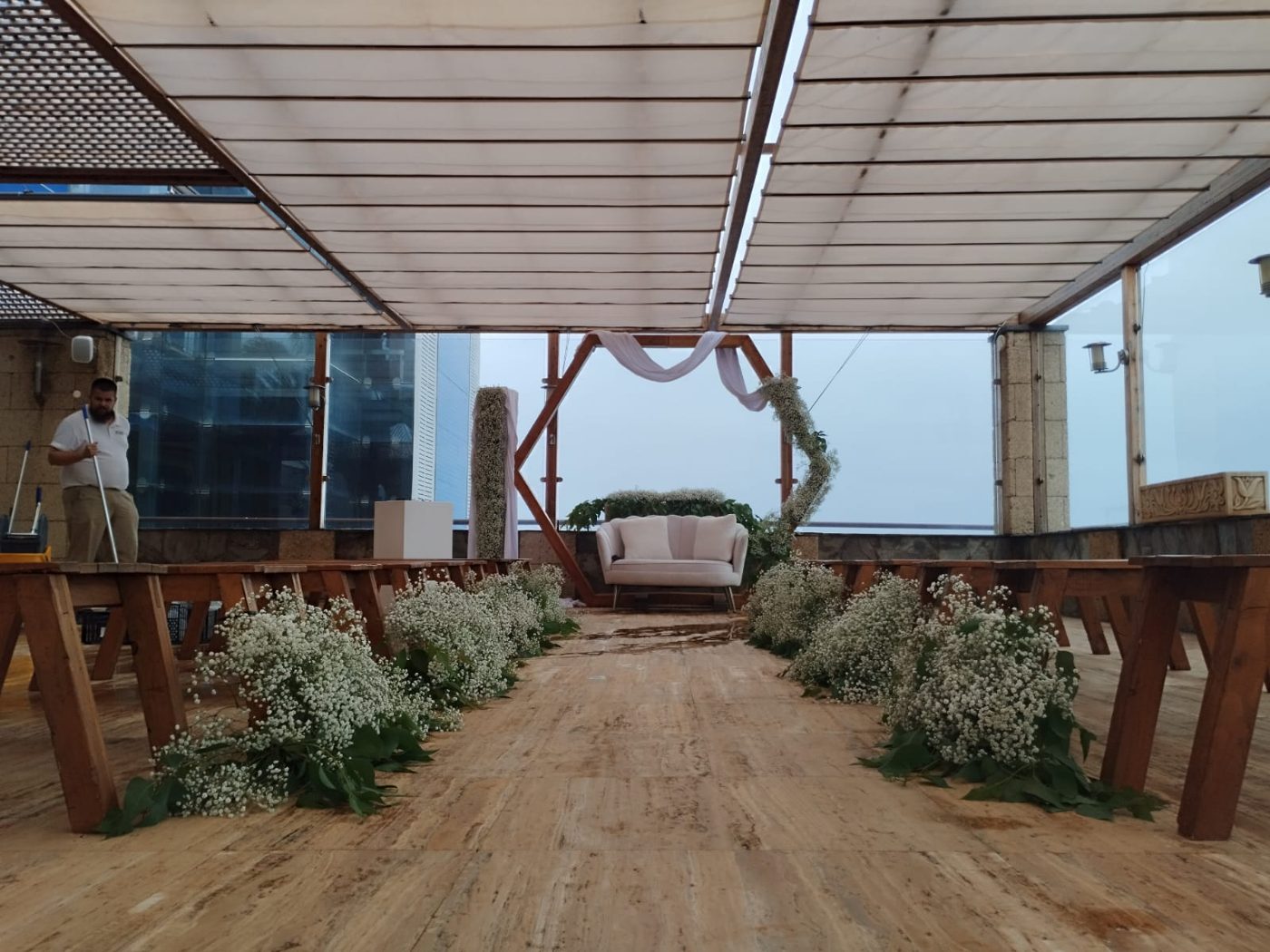 Pasillo en terraza con sofá y arco hexagonal de ceremonia