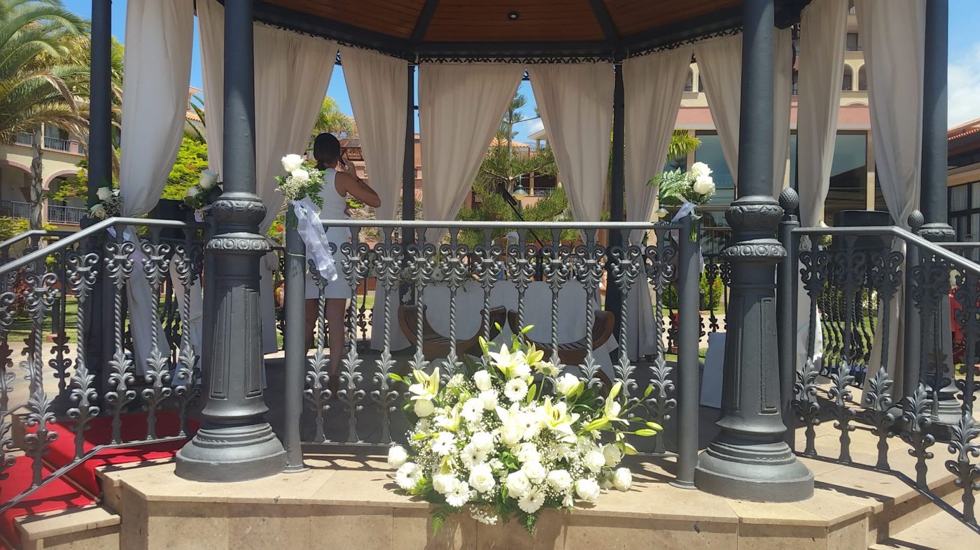 Quiosco de ceremonia con cortinas blancas y flores