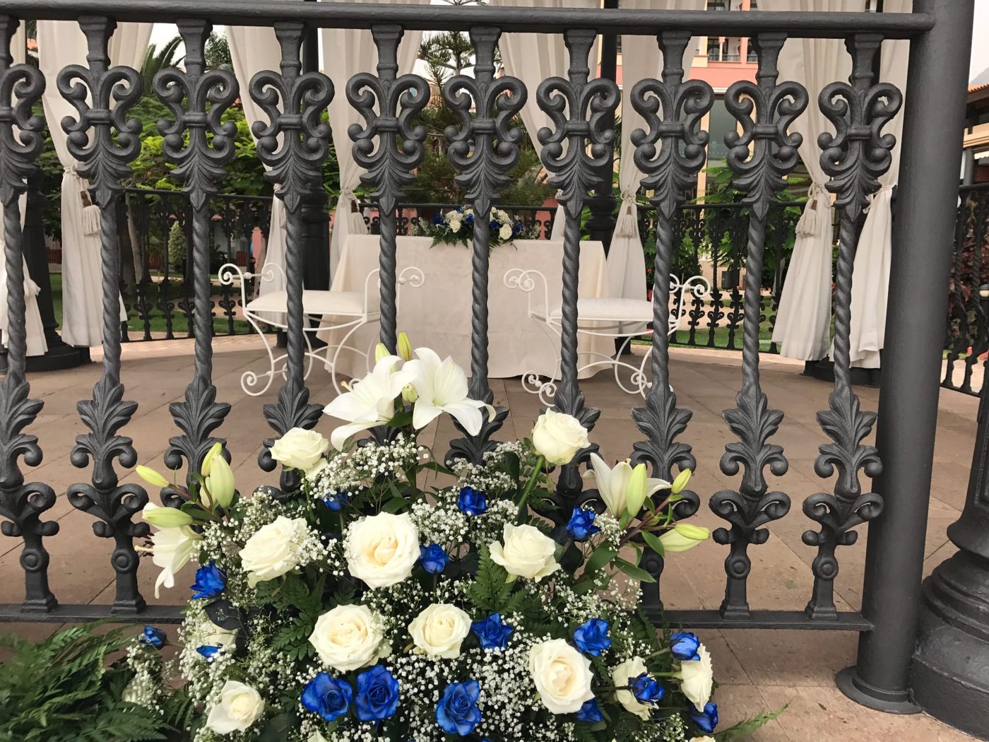 Quiosco de ceremonia con mesa, sillas y flores blancas