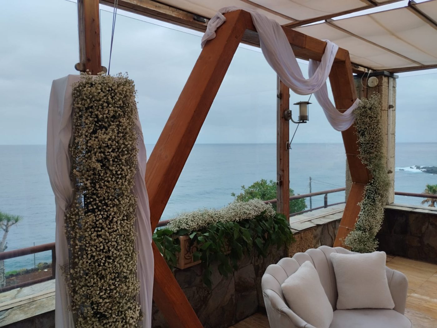 Sofá y arco hexagonal de ceremonia con vistas al mar, otro ángulo