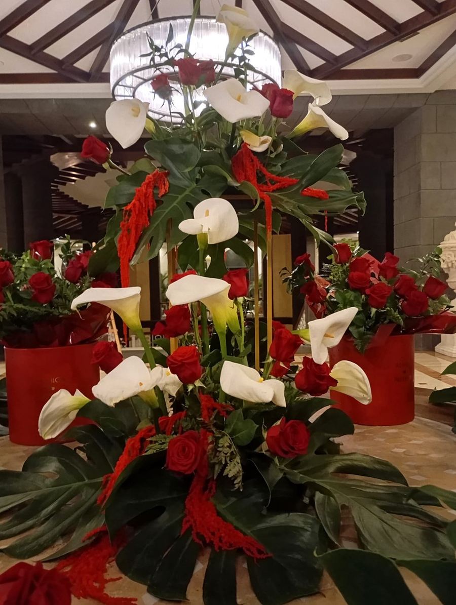 Gran centro de calas y rosas rojas bajo lámpara