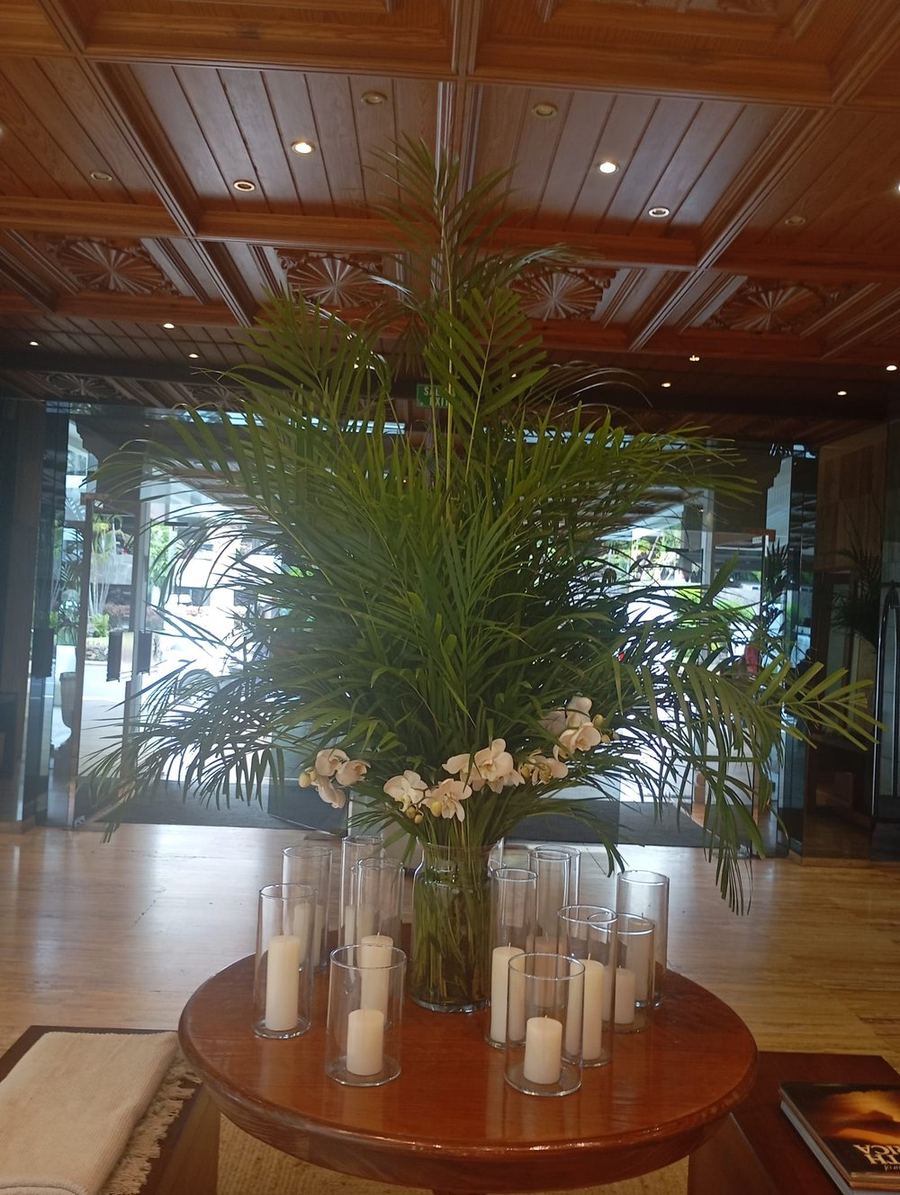 Jarrón con orquídeas y velas sobre mesa de madera