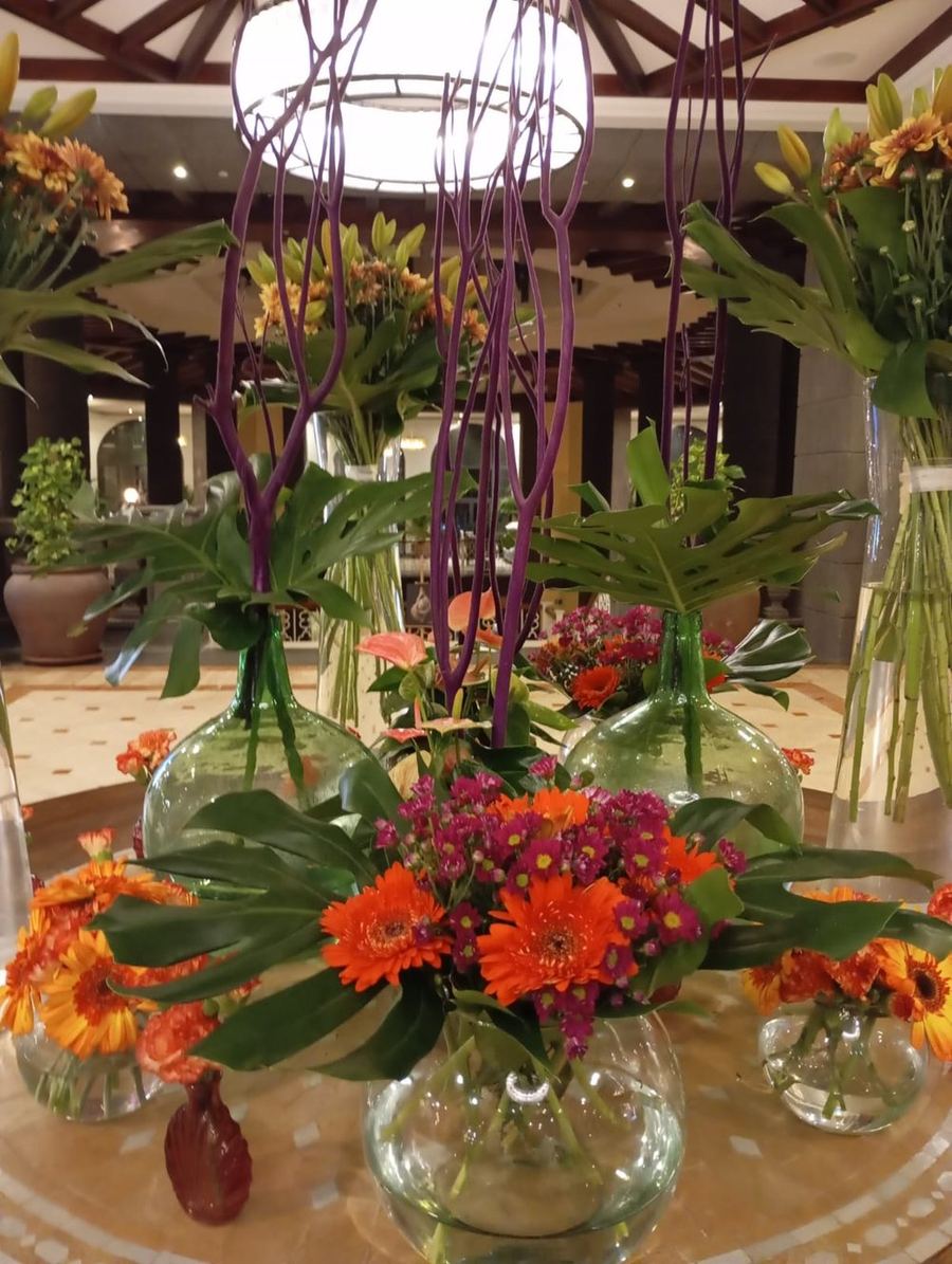 Jarrones de cristal con gerberas naranjas y moradas