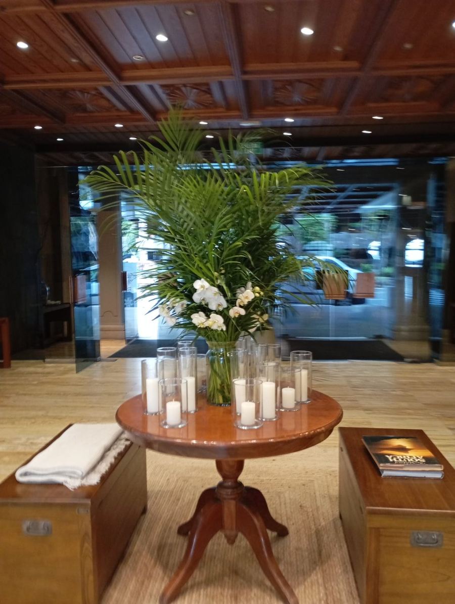 Mesa de recepción con orquídeas blancas, palma y velas