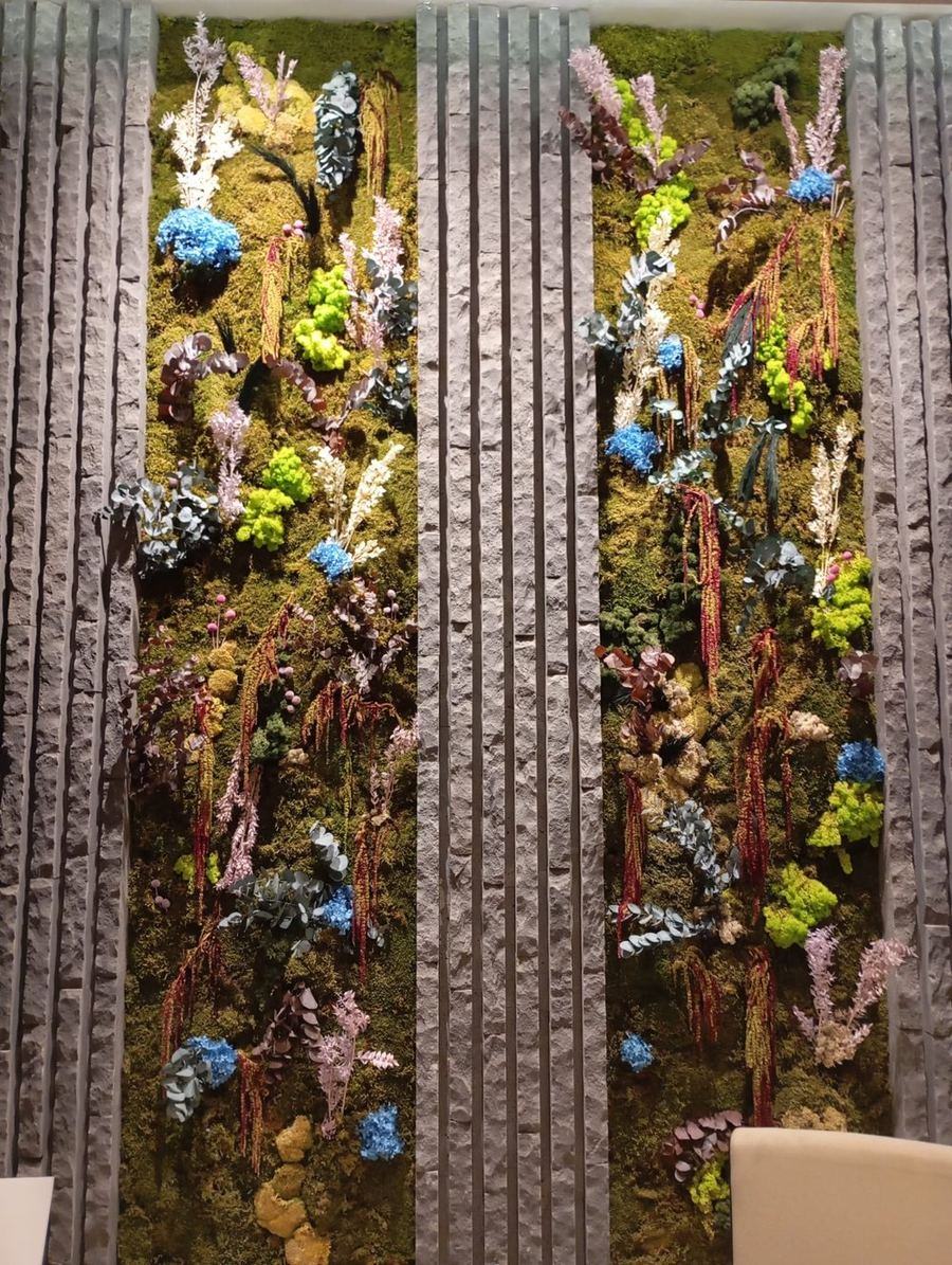 Detalle de pared vegetal con flores preservadas