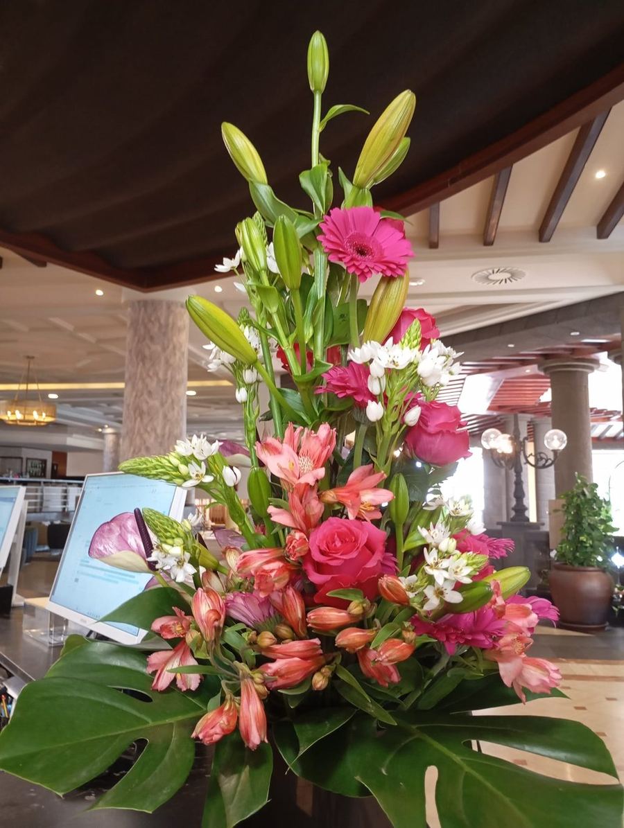Ramo tropical en rosa fucsia sobre mostrador de hotel