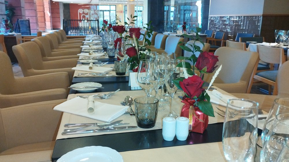 Mesa larga de restaurante con rosas rojas